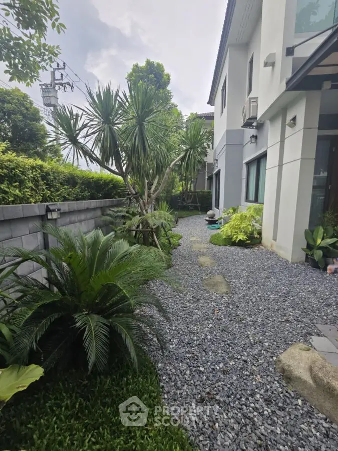 Charming garden view of modern home with lush greenery and stone pathway