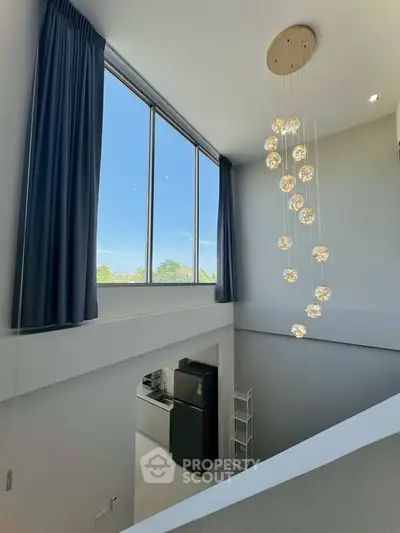 Stunning loft with high ceilings and modern lighting, featuring a large window with a beautiful view.