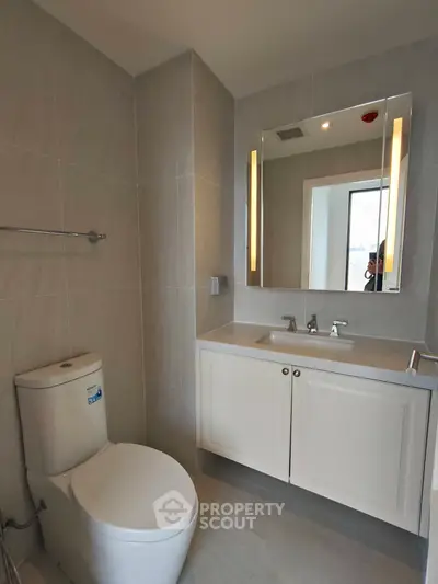 Modern bathroom with sleek fixtures and elegant lighting in a contemporary apartment.