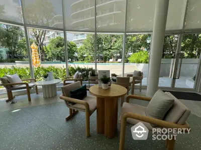 Elegant modern lobby with stylish seating and lush garden view, perfect for relaxation and socializing.