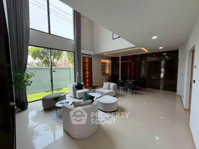 Spacious modern living room with high ceilings and large windows, offering a bright and airy atmosphere.