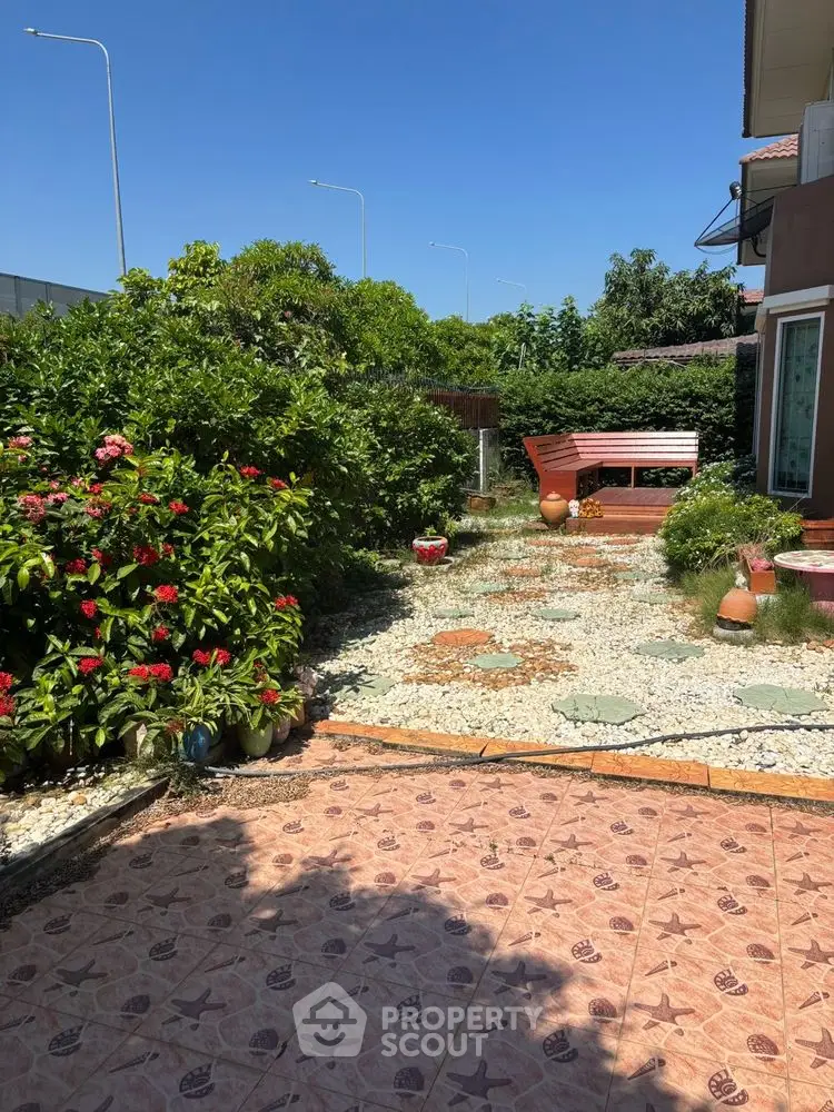 Charming garden with lush greenery and cozy seating area in a residential property.