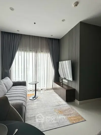 Modern living room with sleek furniture and large window drapes