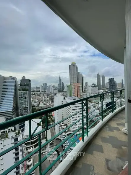 Stunning cityscape view from a high-rise balcony with modern railing.