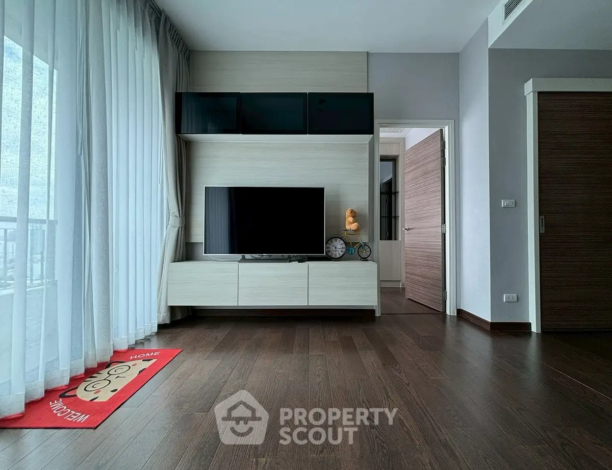 Modern living room with dark wood flooring and sleek TV unit