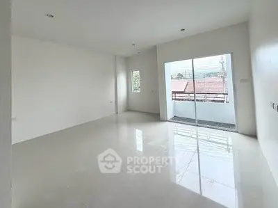 Spacious unfurnished living room with large windows and balcony access.
