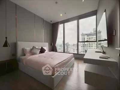 Modern bedroom with large windows offering stunning city views.
