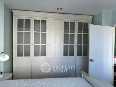 Spacious bedroom with elegant built-in wardrobe and cozy bed setup.
