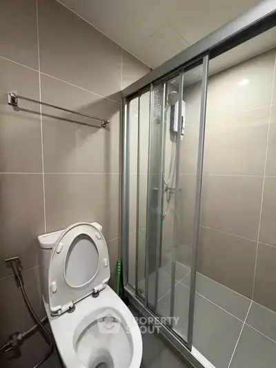 Modern bathroom with sleek shower enclosure and contemporary toilet design.