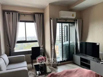 Modern living room with balcony and city view, featuring sleek furniture and air conditioning.