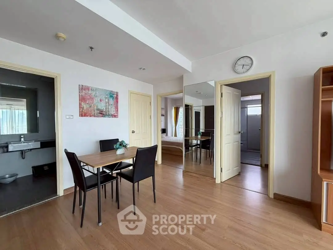 Modern apartment dining area with wooden flooring and mirrored closet doors