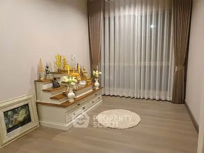 Elegant living room with modern decor and large window draped with sheer curtains.