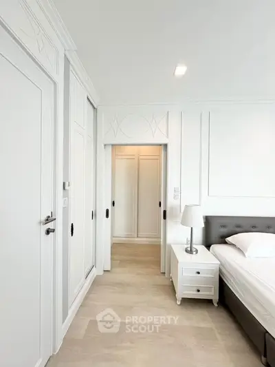 Elegant bedroom with white decor and modern furnishings in a luxury apartment.
