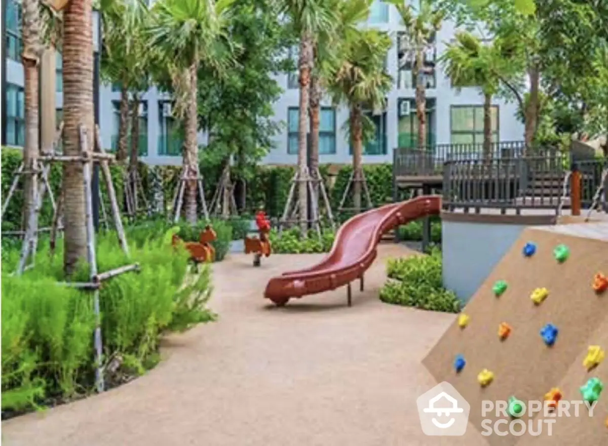 Beautiful garden playground with slide and climbing wall in modern residential complex.