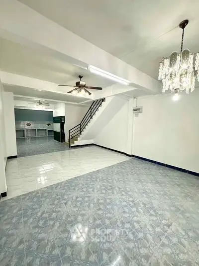 Spacious open-plan living area with modern lighting and tiled flooring