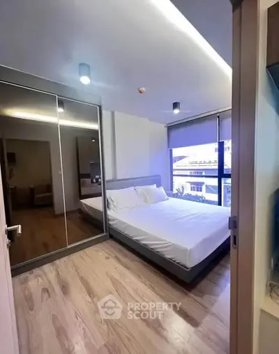 Modern bedroom with mirrored closet and large window view