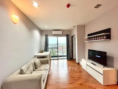 Spacious living room with modern decor and balcony view in urban apartment.