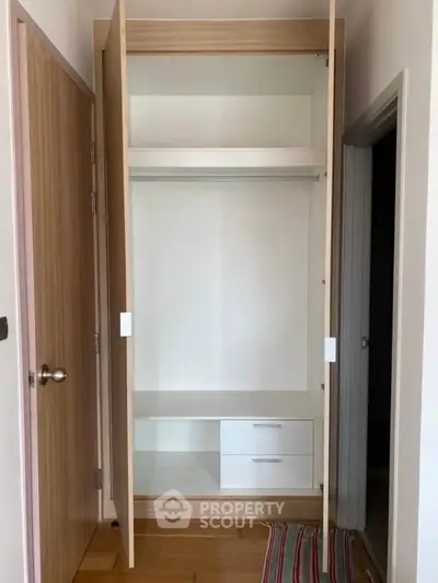 Spacious built-in wardrobe with open doors in modern apartment