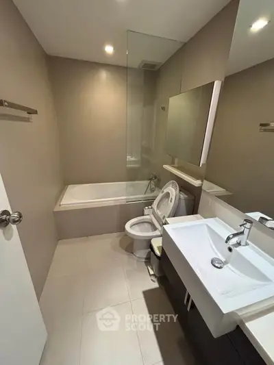 Modern bathroom with sleek fixtures and bathtub in contemporary apartment.