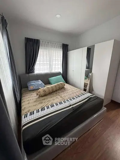 Cozy bedroom with stylish decor and ample natural light, featuring a comfortable bed and modern wardrobe.