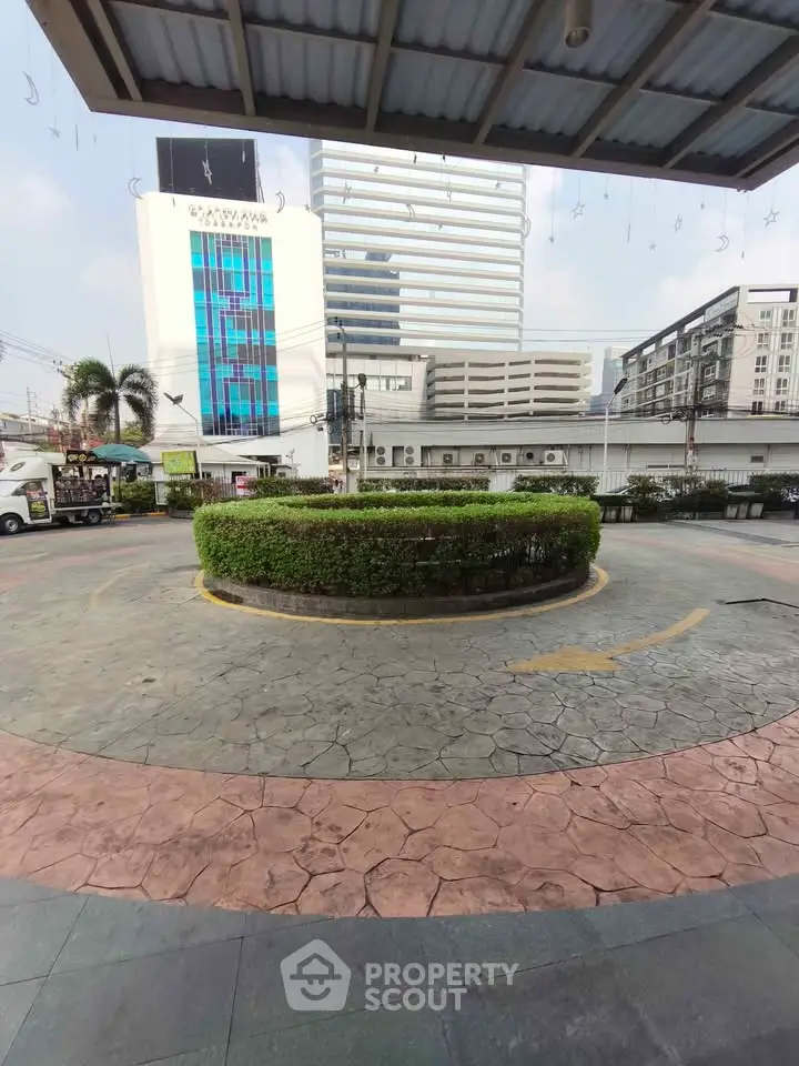 Modern building exterior with landscaped roundabout and city view