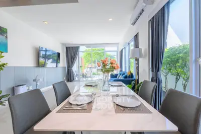 Modern open-plan living and dining area with elegant decor and large windows.