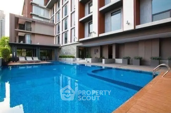 Luxurious apartment building with a stunning outdoor pool and modern design.