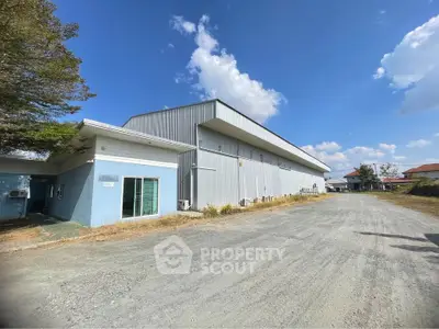 Expansive industrial warehouse with spacious exterior and clear blue sky, ideal for large-scale operations.