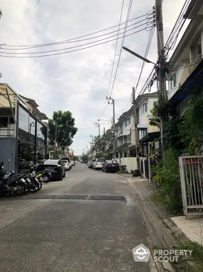 Charming residential street view with modern townhouses and parked vehicles, ideal for urban living.