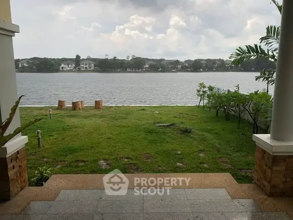 Stunning waterfront view from a luxurious property with lush green lawn and serene ambiance.