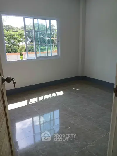 Bright empty room with large window and glossy tiled floor, perfect for customization.