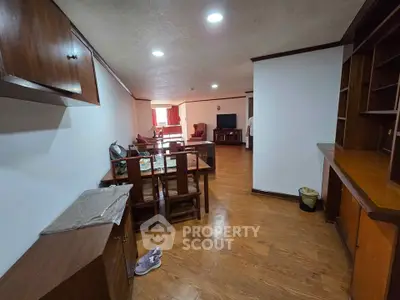 Spacious living room with wooden flooring and dining area, perfect for family gatherings.