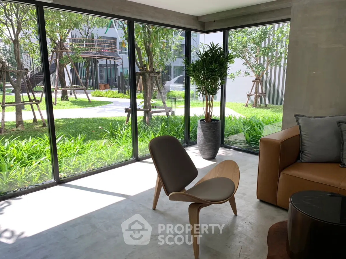 Modern living room with large windows overlooking lush garden