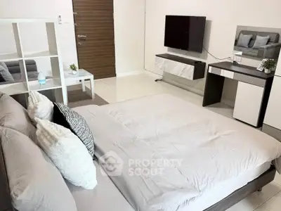 Modern bedroom with stylish decor and wall-mounted TV in a cozy apartment.