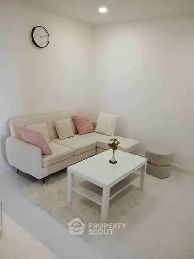 Cozy living room with modern white sofa, coffee table, and stylish decor accents.