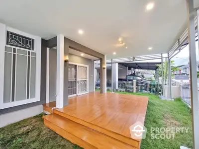 Modern home entrance with wooden deck and garden view