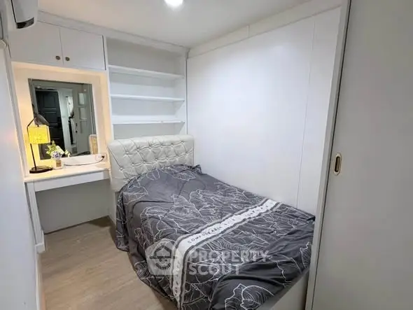 Cozy bedroom with built-in shelves and modern decor, perfect for a compact living space.