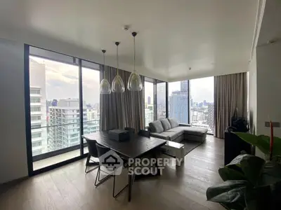 Modern living room with city view, large windows, and stylish furniture in a high-rise apartment.