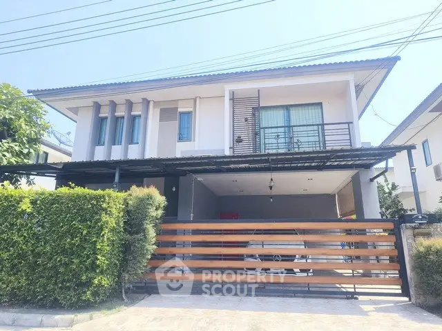 Modern two-story house with carport and lush greenery in a suburban neighborhood.