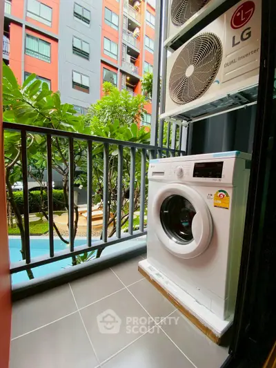 Modern balcony with washing machine and air conditioning units overlooking pool and garden.