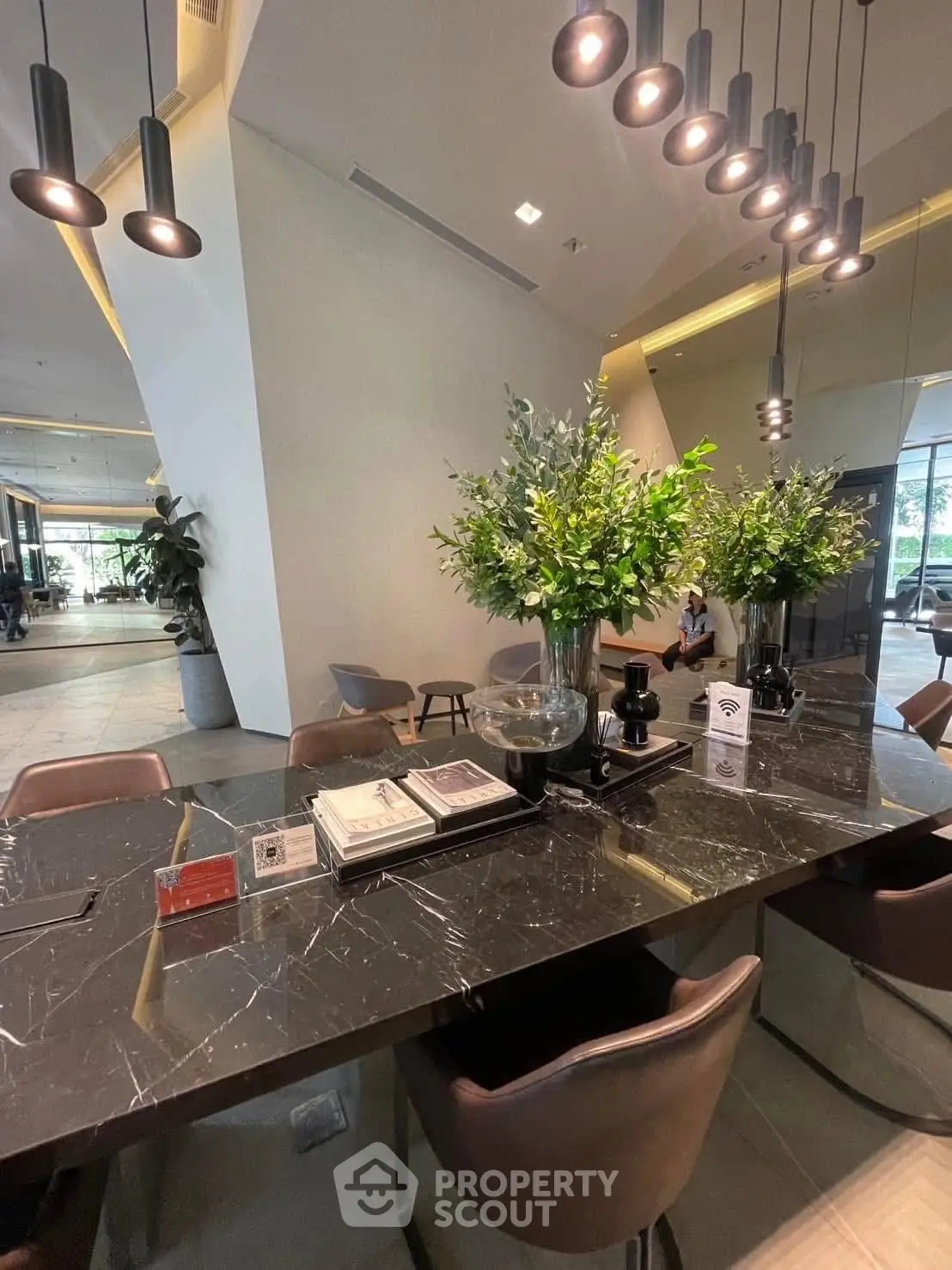Luxurious modern lobby with elegant marble table and stylish lighting in upscale building.