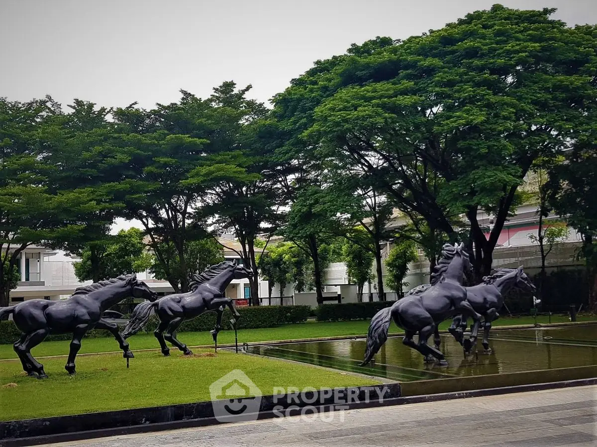 Stunning garden view with elegant horse sculptures and lush greenery in a luxury estate.