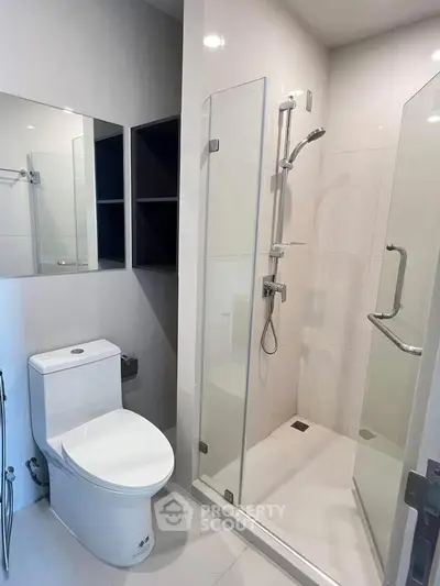 Modern bathroom with glass shower enclosure and sleek fixtures.