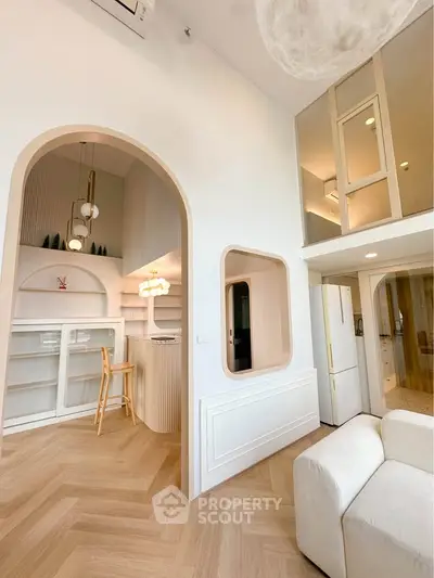 Modern open-plan living area with stylish archway and loft space