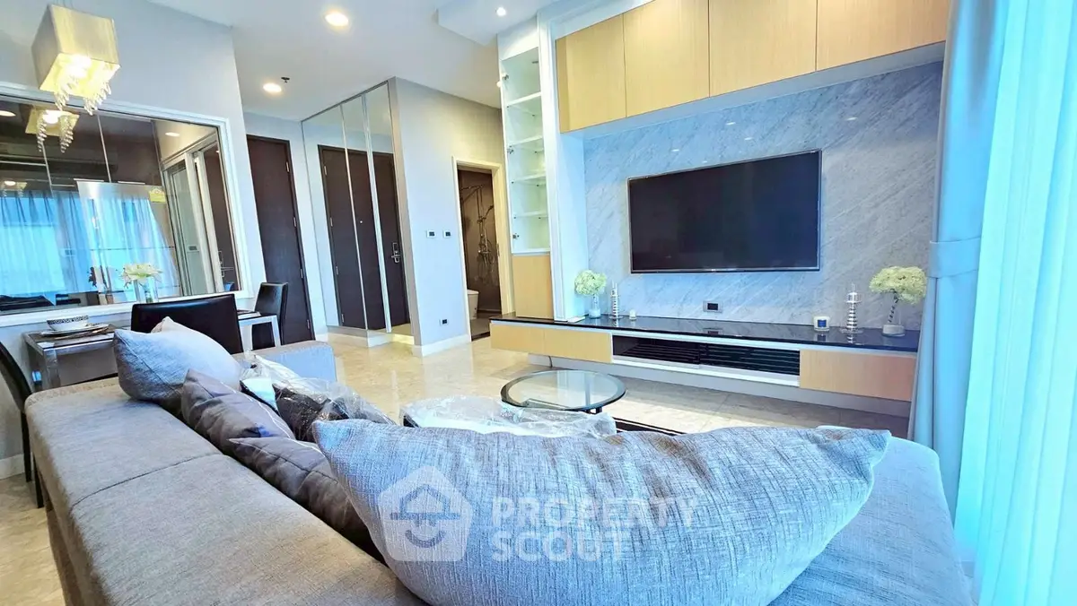 Luxurious modern living room with sleek design and large TV, perfect for relaxation.