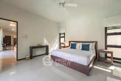 Spacious modern bedroom with natural light and elegant furnishings