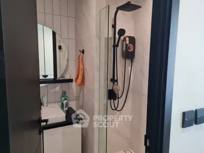 Modern bathroom with sleek shower and stylish vanity in contemporary home.
