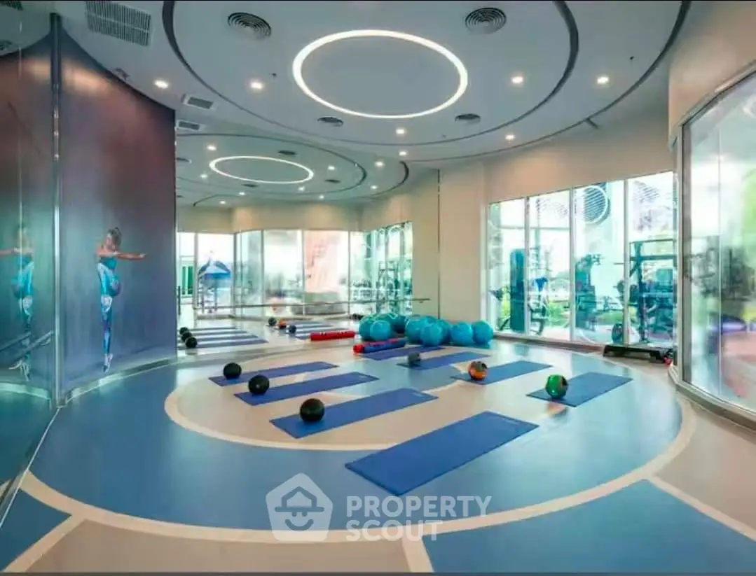 Modern gym with yoga mats and exercise balls in a luxury building.