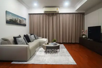 Elegant living room with modern sofa, stylish decor, and warm wooden flooring.