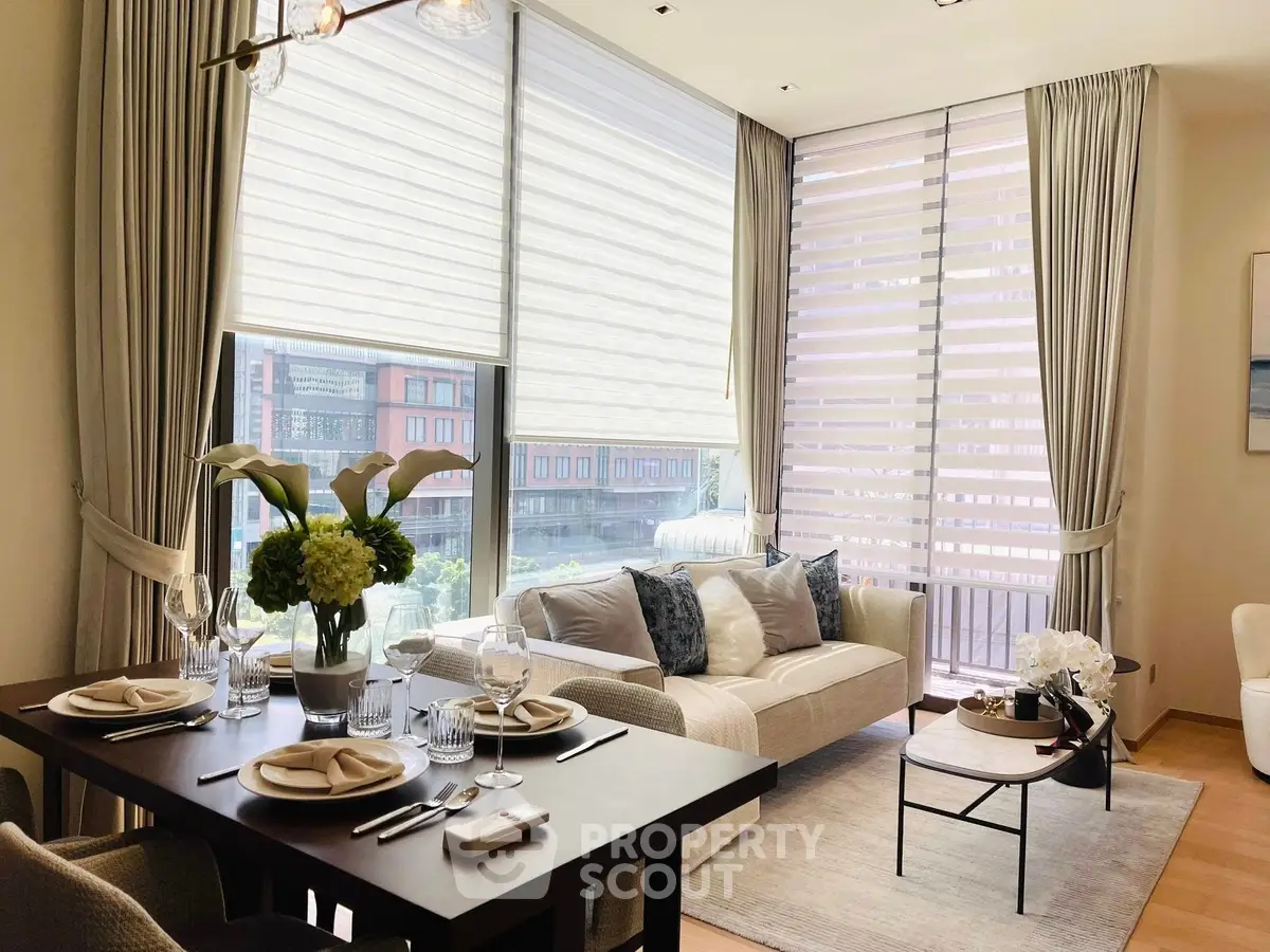 Elegant living room with large windows, modern decor, and dining area, perfect for urban living.